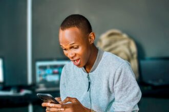 a man looking at his cell phone and laughing